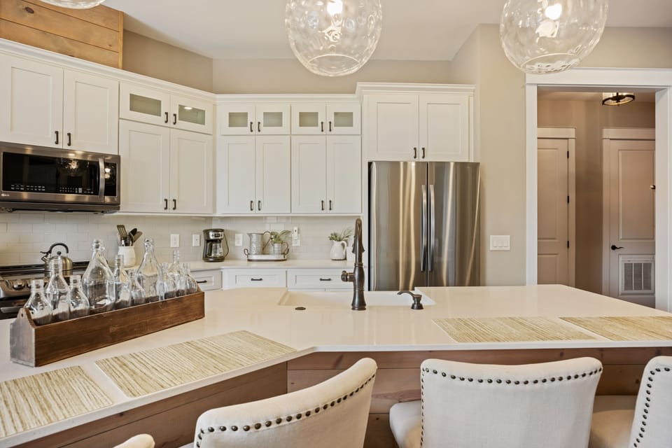 Modern kitchen w/ stainless appliances, granite island, dining for four.