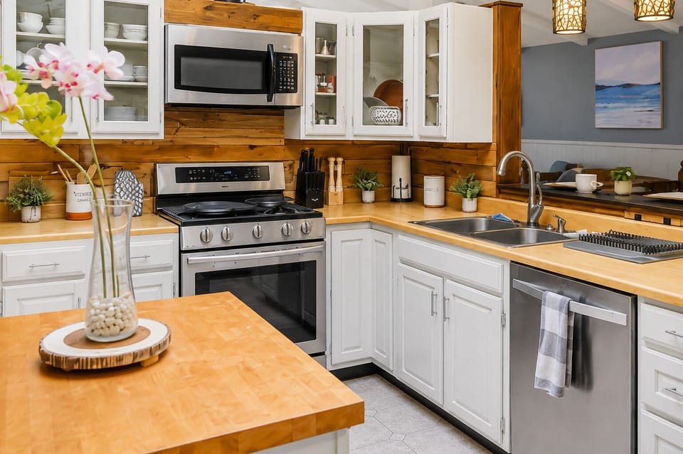 Renovated kitchen with stainless appliances and a gas range
