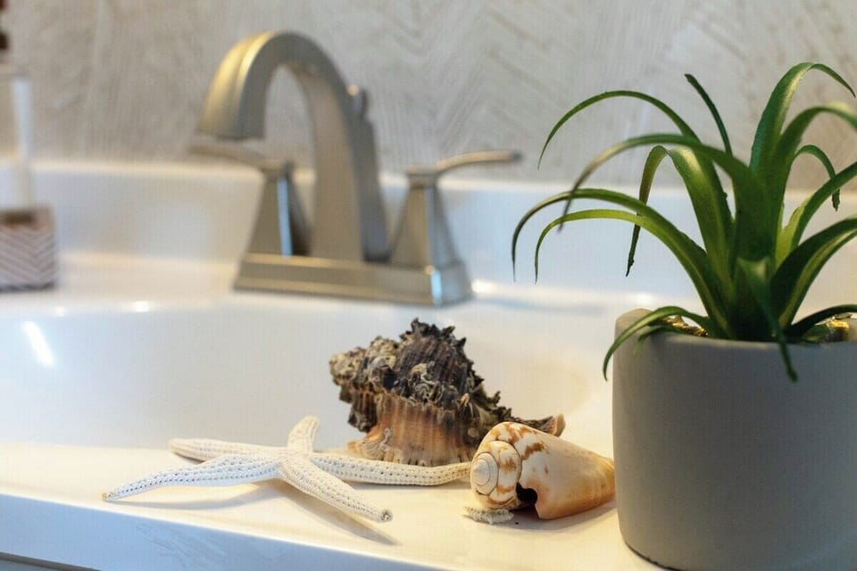 Discover the charm of the coast as seashells delicately grace the bathroom sink.