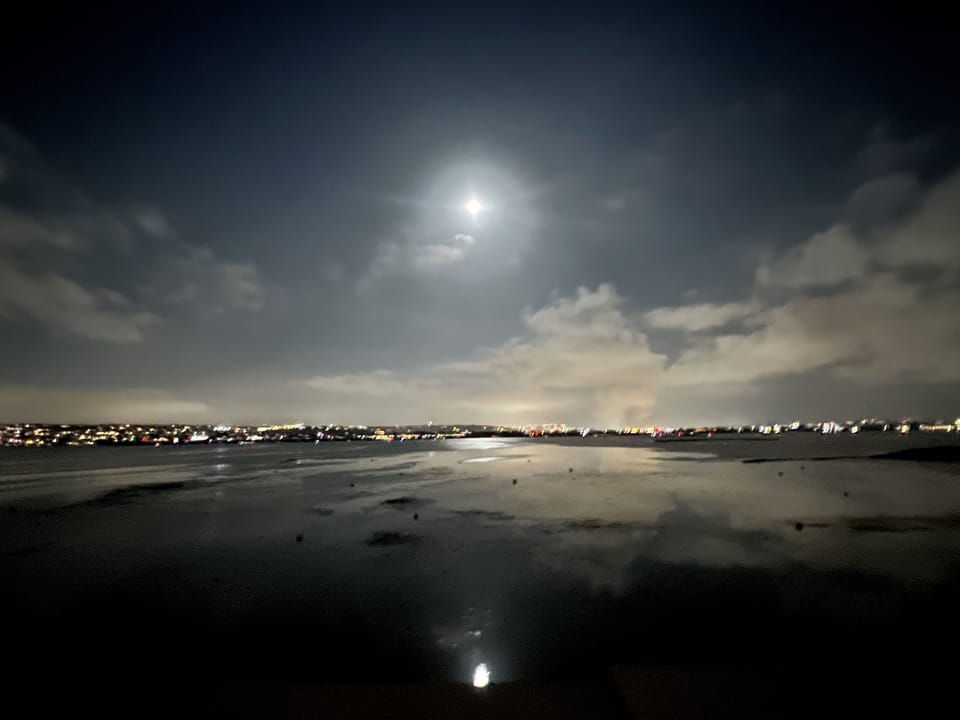 Full moon reflecting on bay from balcony.