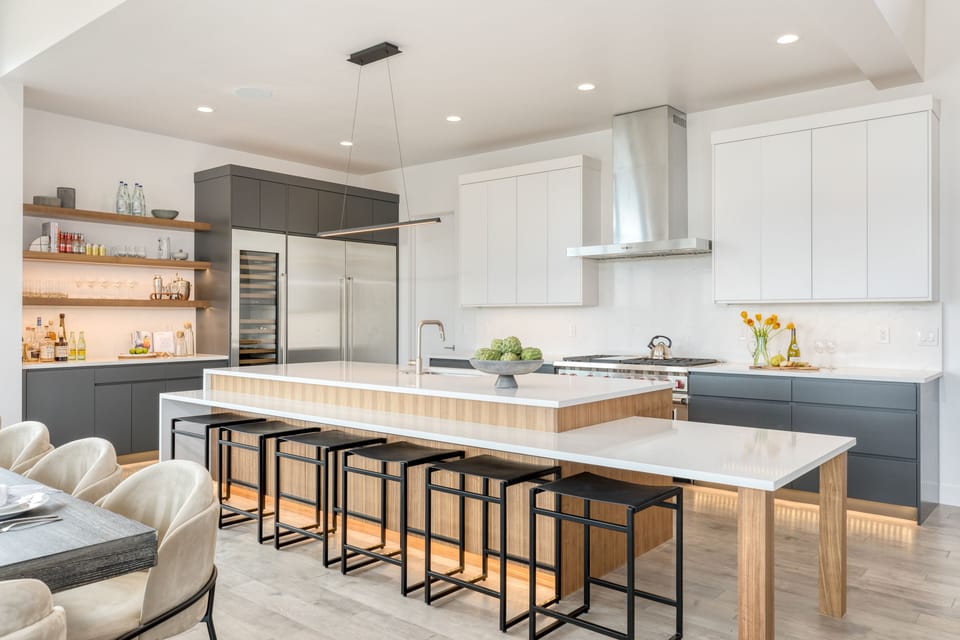 Fully-equipped kitchen with high-end appliances and additional barstool seating at the counter.