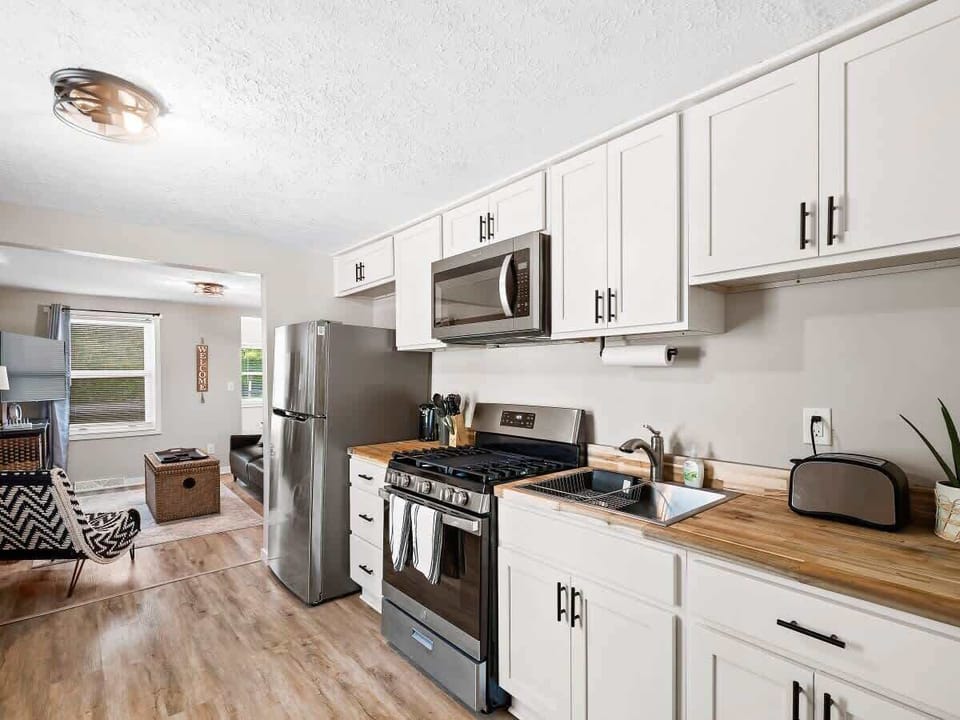 Whip up meals with ease in this modern kitchen featuring butcher block counters, gas stove, and a coffee bar ready to fuel your mornings! ✨
