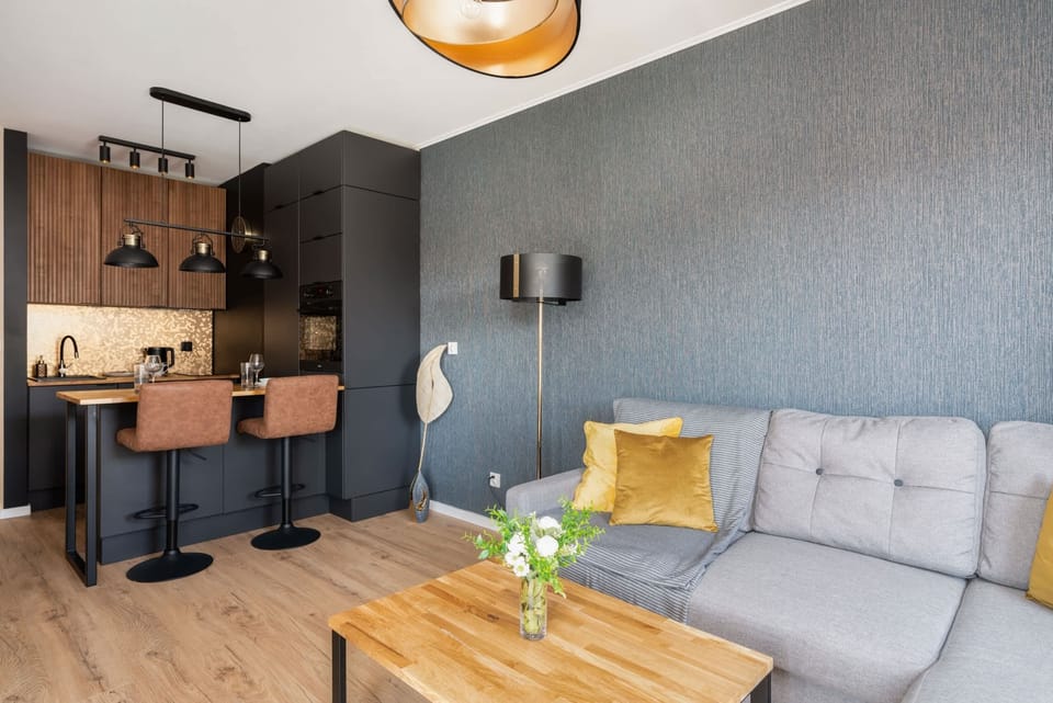 A stylish living room featuring a gray sofa with yellow throw pillows, a coffee table, and modern decor elements.