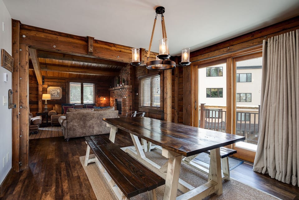 Picture yourself sharing meals at this handcrafted wood table beneath the warm glow of rope lighting, then unwinding on the plush sofa by the fireplace, all within a stunning timber retreat.