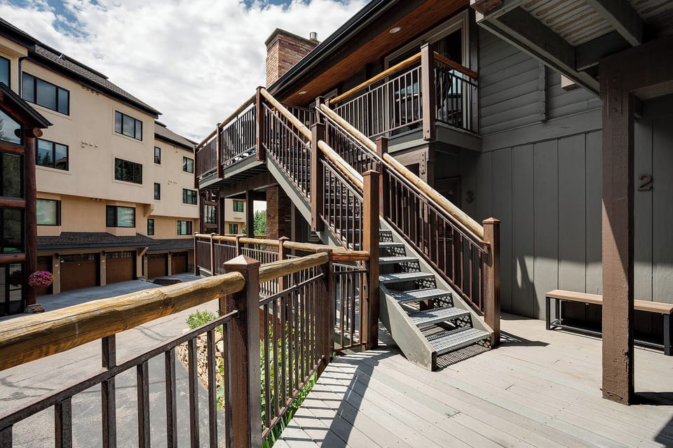 Step out onto your private deck featuring warm wood railings and mountain-style architecture, perfect for morning coffee or evening relaxation.
