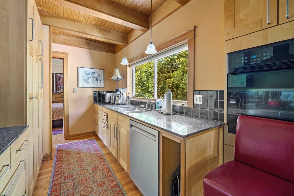 Cook in your fully equipped gourmet kitchen with granite counters, exposed beams, and garden views.