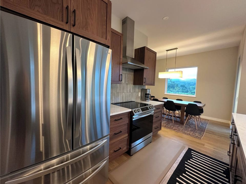 Kitchen with stainless appliances, induction stove, and adjacent dining views