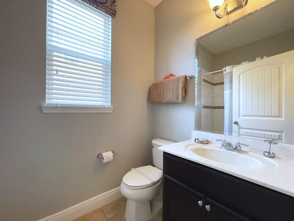 The full bathroom offers a single vanity, shower, and bright lighting, providing comfort and convenience throughout your stay.
