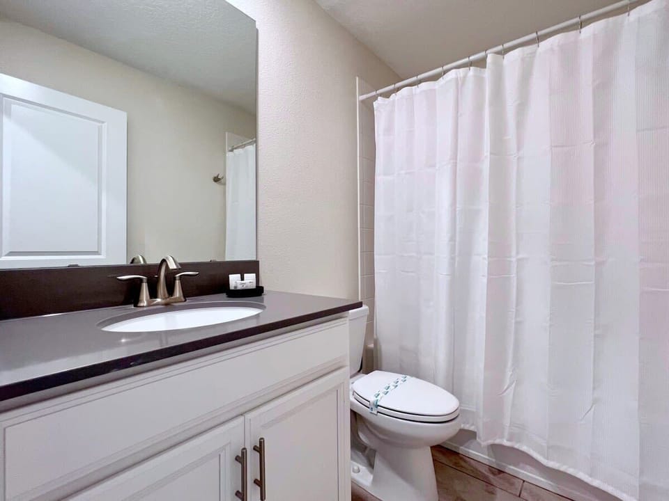 Bright full bathroom featuring a single vanity, shower, and modern finishes for a comfortable and refreshing experience.