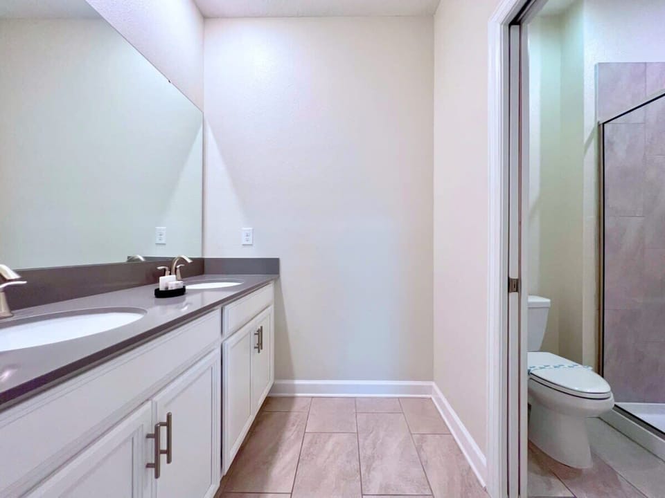 Bright full bathroom featuring a double vanity, shower, and modern finishes for a comfortable and refreshing experience.
