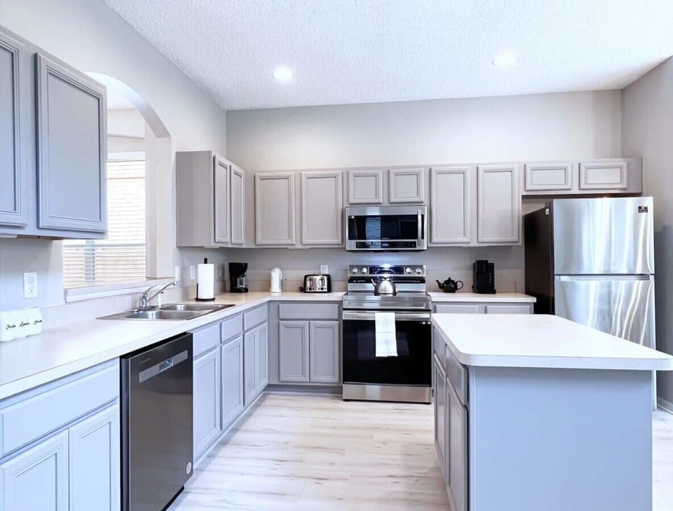 The open-concept kitchen features stainless steel appliances, ample counter space, and everything you need to prepare family meals during your vacation.