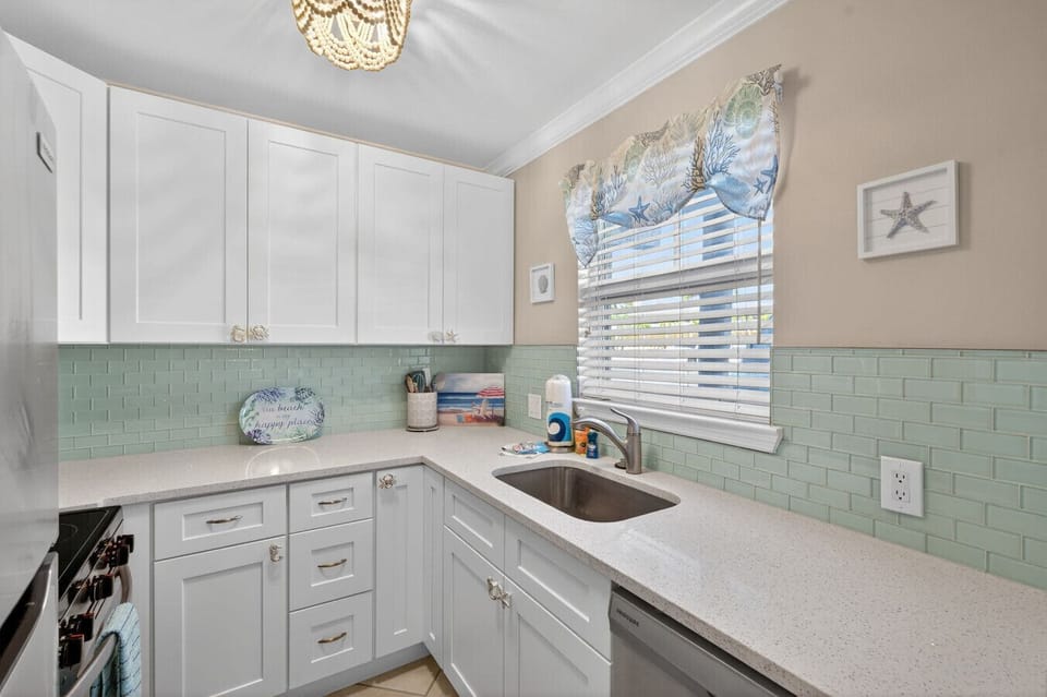 Bright kitchen corner w/ tiled backsplash, sink & plenty of counter space.