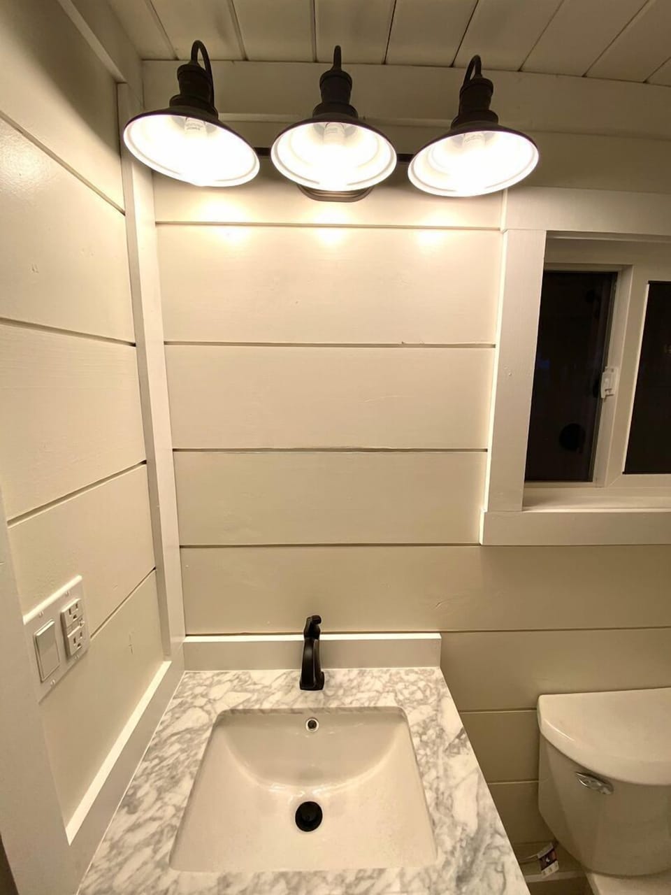 Plenty of lighting in the bathroom along with a beautiful marble sink.