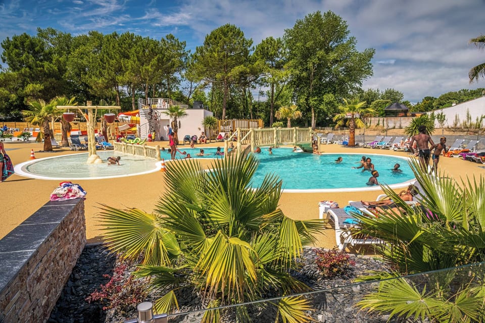 Relax in the serene surroundings of the refreshing pool, embraced by tropical palm trees, ensuring endless enjoyment for families at this delightful seaside resort.