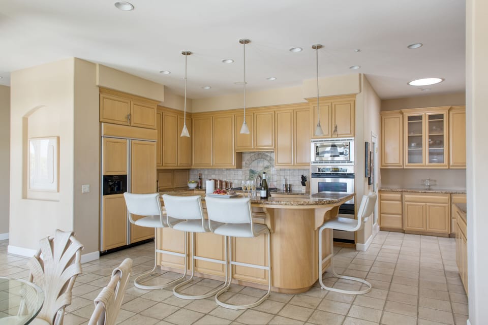 Fully-equipped kitchen with modern appliances and additional barstool seating at the counter.