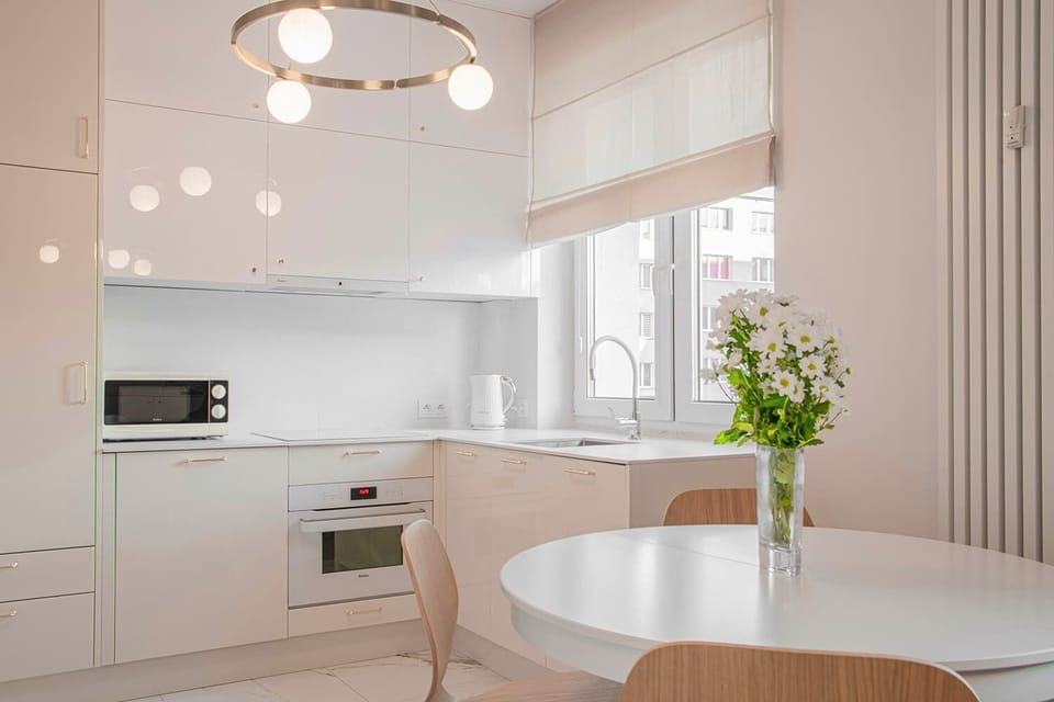 Kitchen and dining space with round table – Functional open kitchen with modern cabinetry and stylish lighting.