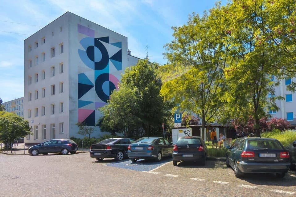 A lively view of the surrounding buildings and trees from the outside of the apartment.