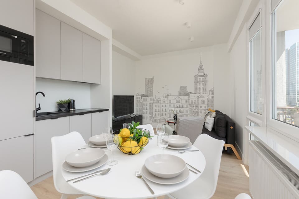 A small dining area near the window, set up with four chairs, perfect for intimate meals with a view.