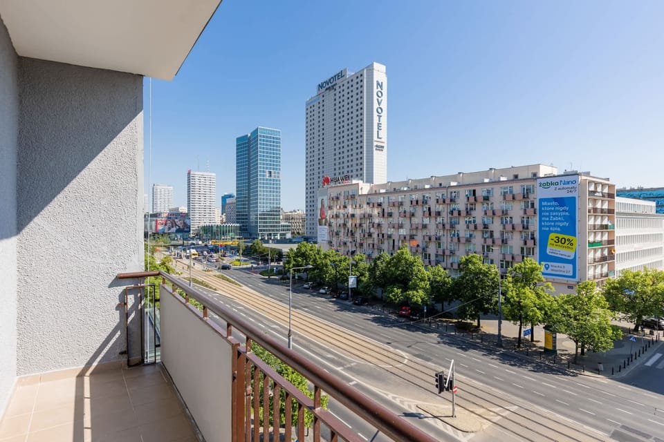 A photo showing the view from the apartment, featuring iconic city buildings and lush greenery below.