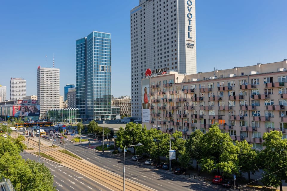 A photo showing the view from the apartment, featuring iconic city buildings and lush greenery below.