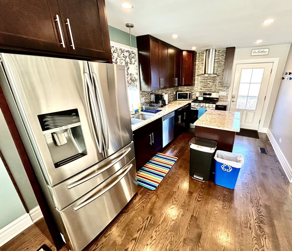 Kitchen with appliances, cookware, coffee, creamer, sugar & dish pods.