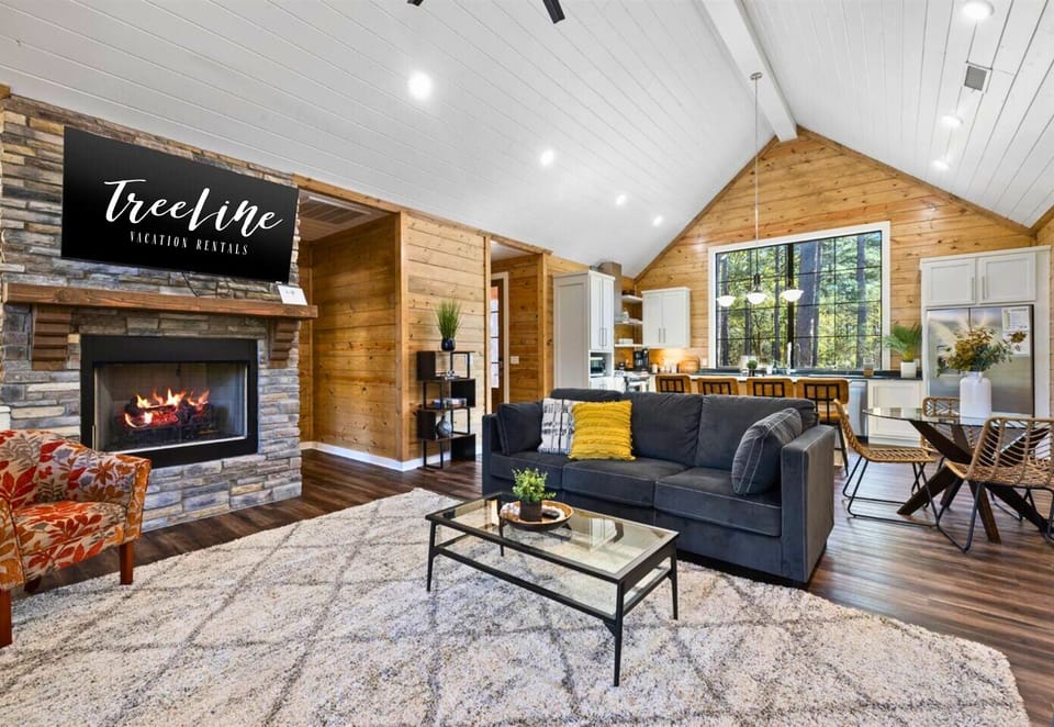 Sink into comfort by the fireplace, your living room framed by nature.