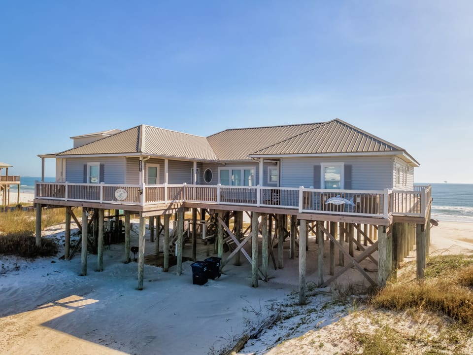 Spacious stilted beach house with wraparound decking and panoramic water views. Prime Gulf-front location offering privacy and direct beach access.