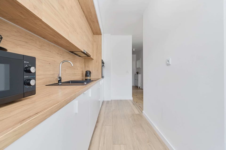 Another view of the kitchen, showcasing its efficient layout and natural wood details.