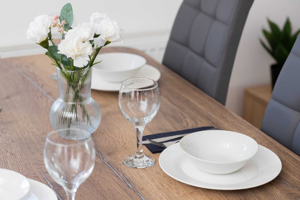 A close-up of the dining table, set for two with wine glasses and simple yet stylish decor.
