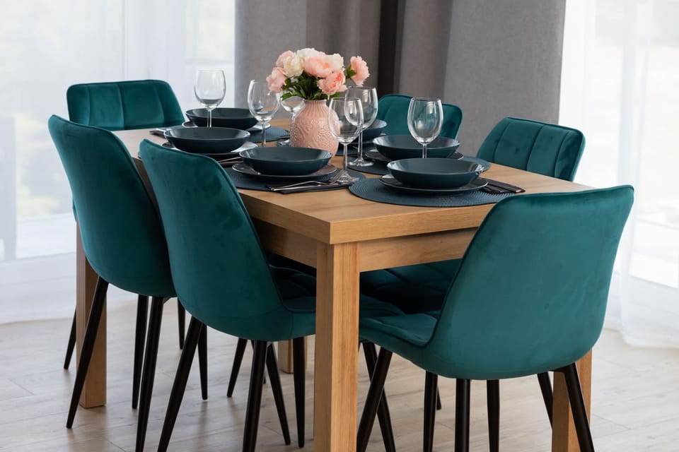 A beautifully arranged dining table with blue chairs, ready for a meal.