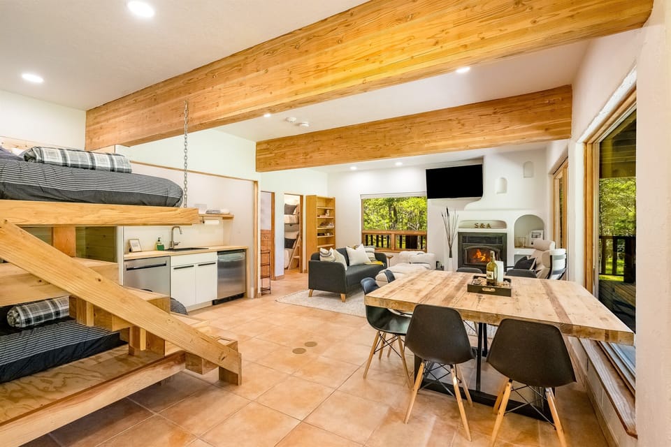 The lower level living space serves as a studio with dining table, kitchenette, living area, fireplace, and full over full bunk beds - all with amazing views
