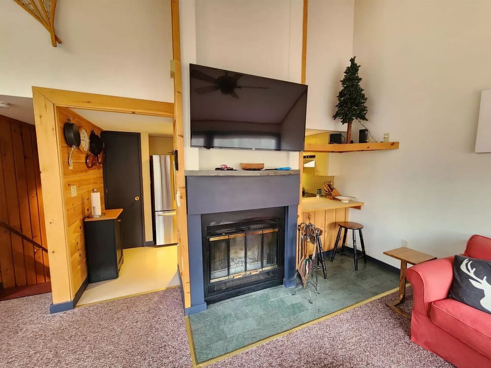 App enabled TV and Wood burning fireplace in living room. 