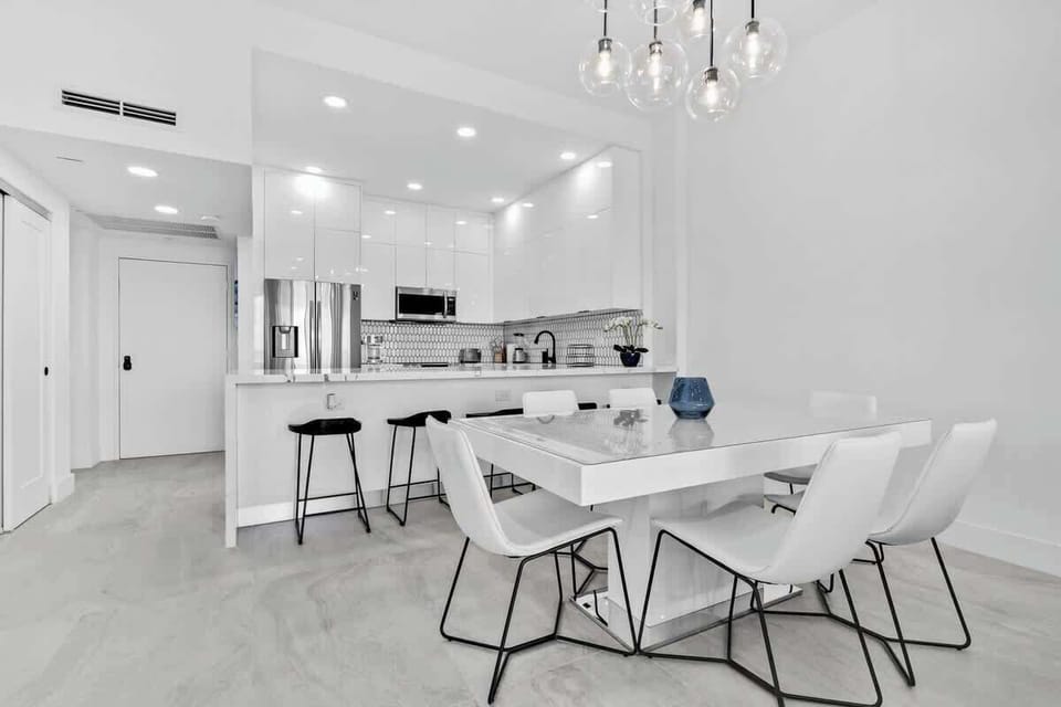 Bright, modern kitchen & dining space! Gather around the sleek white table for meals with style.