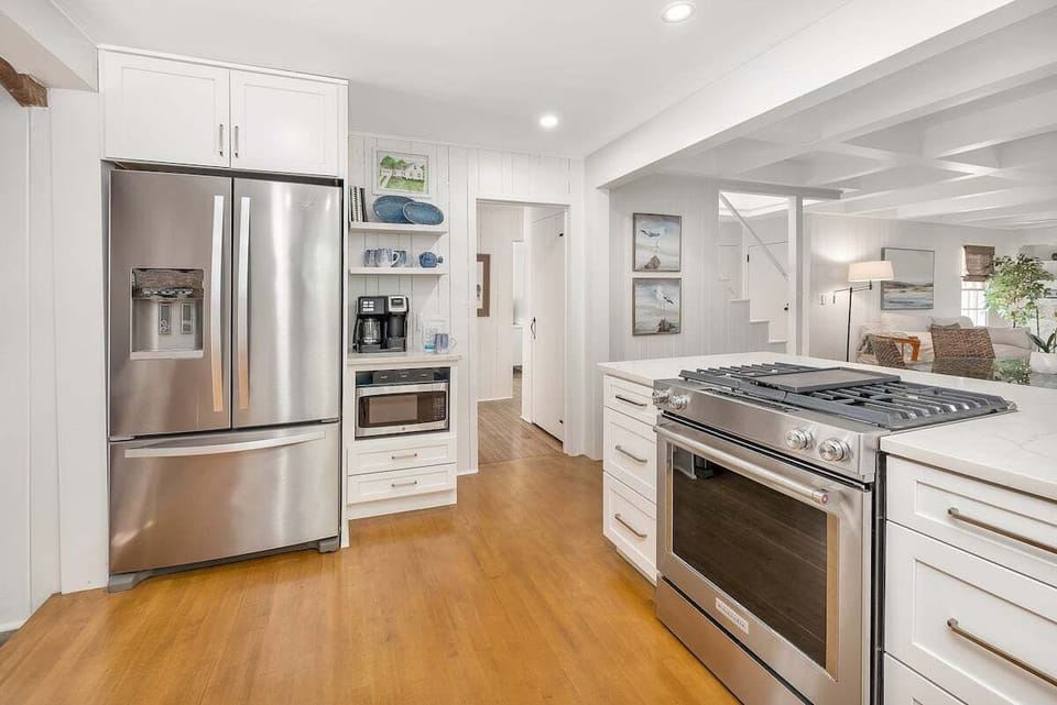White kitchen with stainless fridge and gas range