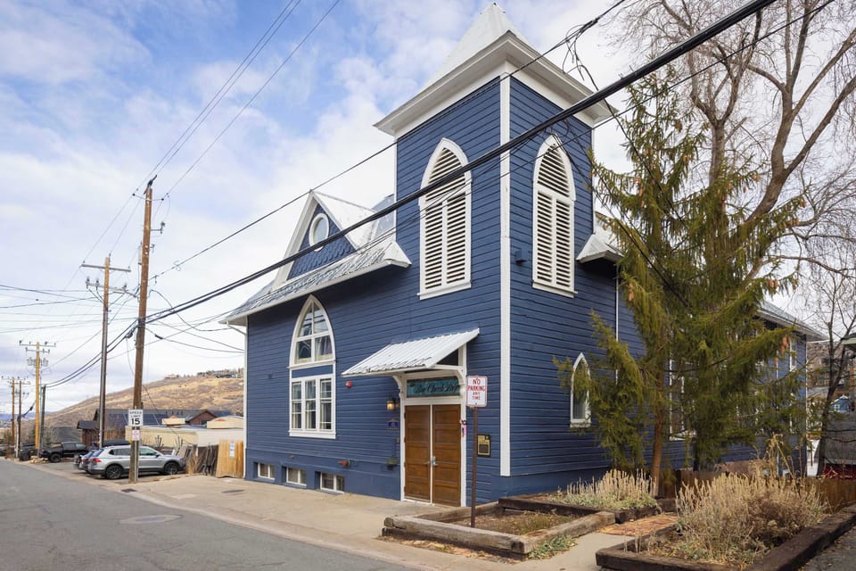 An exterior view of the building the home is located in, the historic Blue Church Lodge, a Victorian-era style building steps away from Old Historic Main Street.