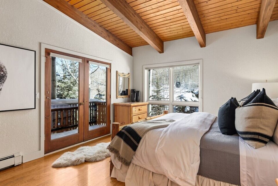 Fourth floor king-sized bedroom with private deck, ensuite bathroom, and views of Funnel ski run.