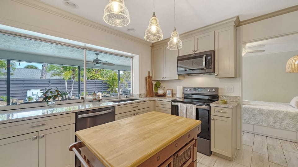 Prepare delicious meals with a view! Our kitchen features multiple outdoor windows overlooking the inviting pool area. Cooking never felt this refreshing. 🍳🌴 #PoolsideCooking #KitchenViews  🏊‍♂️🍽️