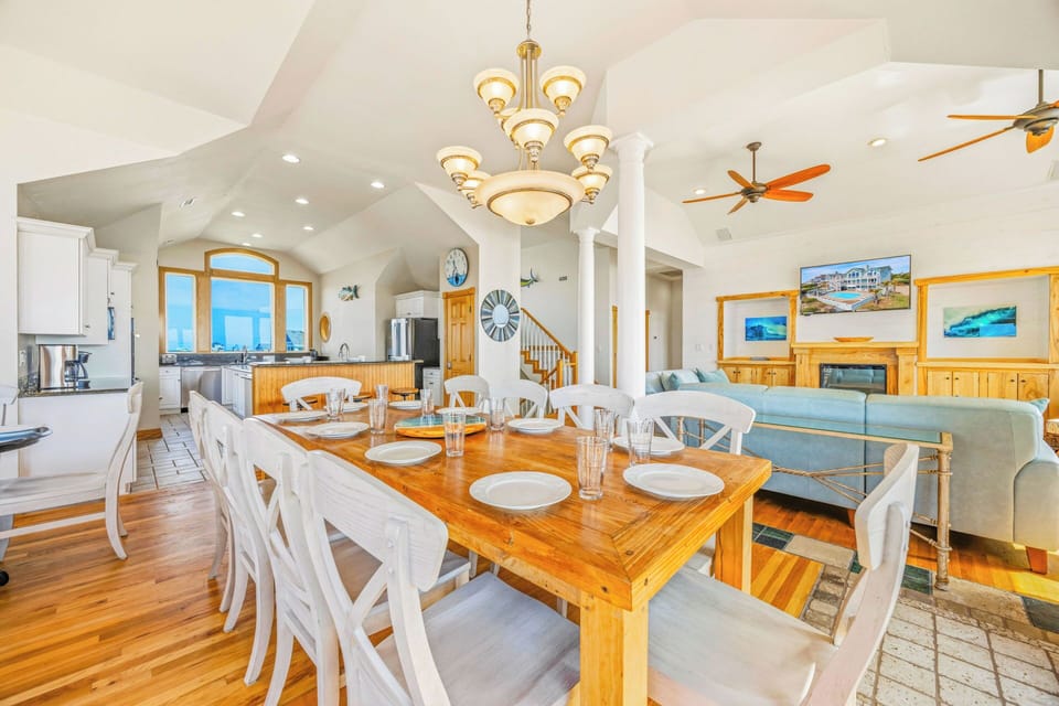 Picture yourself gathering with loved ones in this sun-drenched open-concept space, where coastal charm meets comfort. Enjoy meals at the farmhouse table, relax by the fireplace, and let ocean breezes flow through this inviting home.