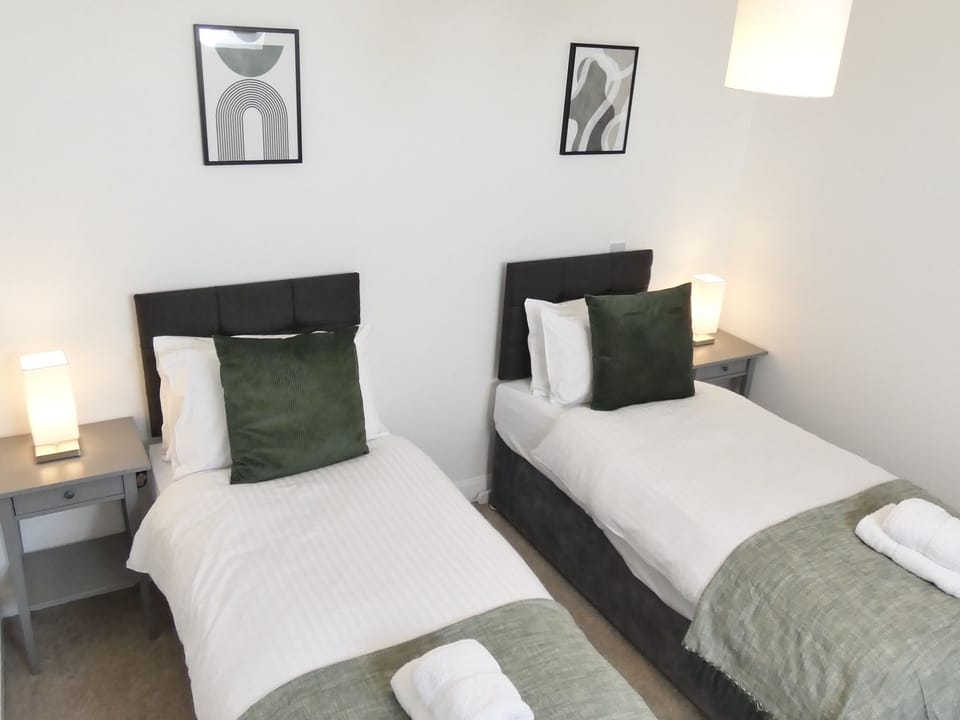 The bedroom is designed for flexibility and comfort, featuring two single beds with a unique zip and link option. 