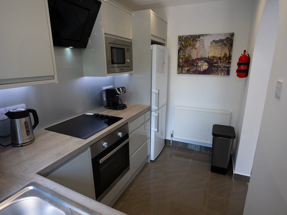 The central elements in this kitchen space are strategically positioned, featuring a well-placed kettle, stove, and microwave.