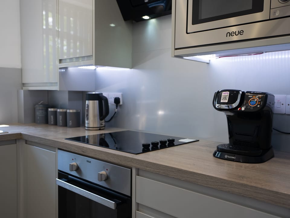 The kitchen showcases both a coffee maker and a stove