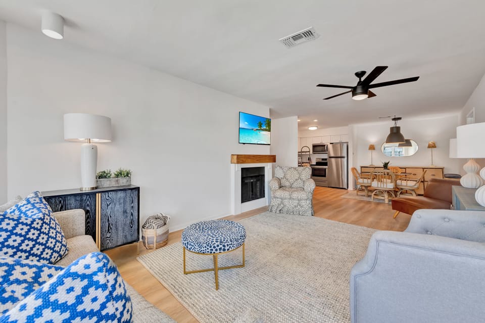 Relax in your stylish open-concept living space with cozy fireplace, modern kitchen, and thoughtful coastal touches throughout.