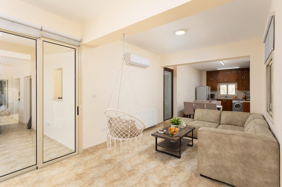 Open-plan living room with sofa, dining area, kitchen, A/C, WiFi internet, satellite TV, and terrace access