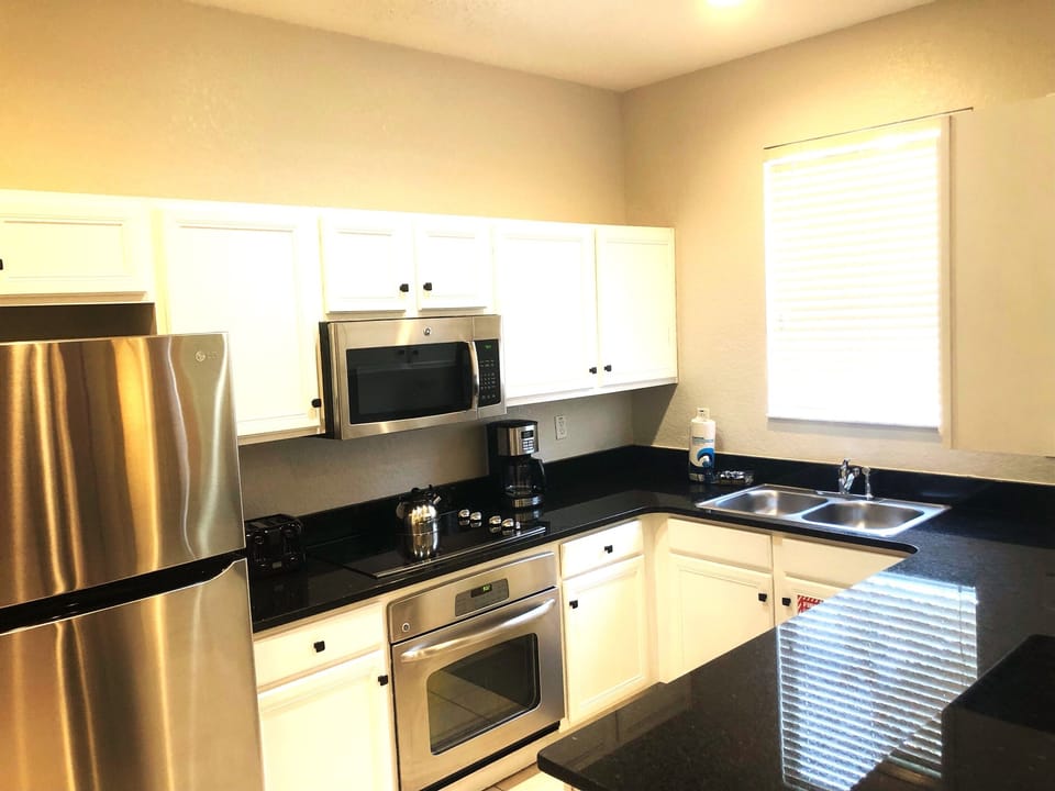 Fully equipped kitchen with stainless appliances and solid surface countertops