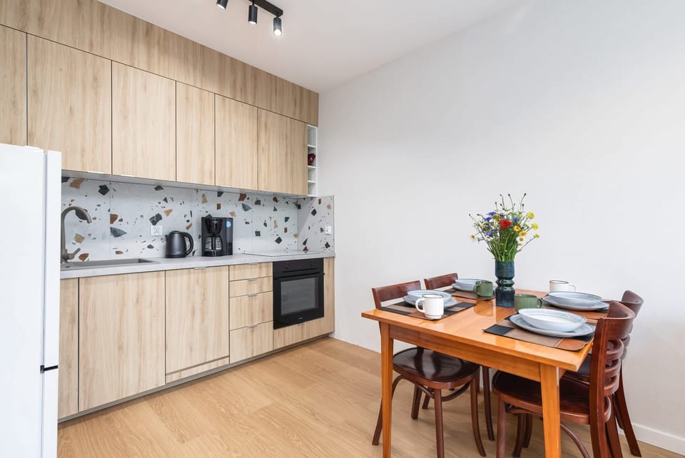 Kitchenette and dining area with table and tableware.