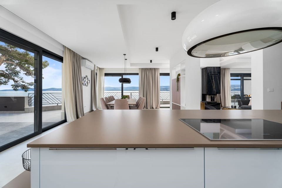 Fully equipped kitchen with an island and luxuriously decorated dining room with a magical view of the crystal blue sea