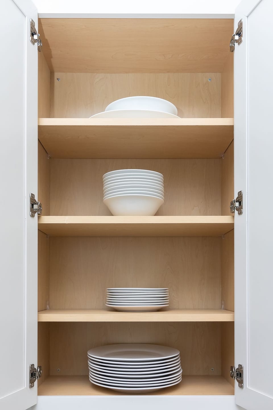 Fully equipped kitchen with plates, bowls, pots and pans. 