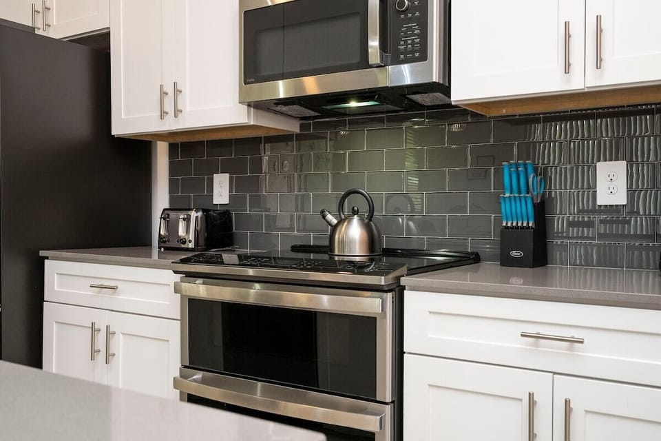 The fully equipped kitchen features modern appliances, sleek cabinetry, and all essential cookware and utensils, making it perfect for preparing meals with ease.