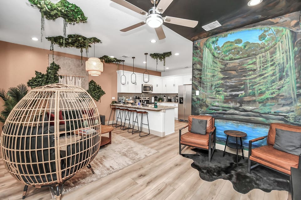Living Room with Egg Shaped Chair, Single Couches and Hand Painted Mural