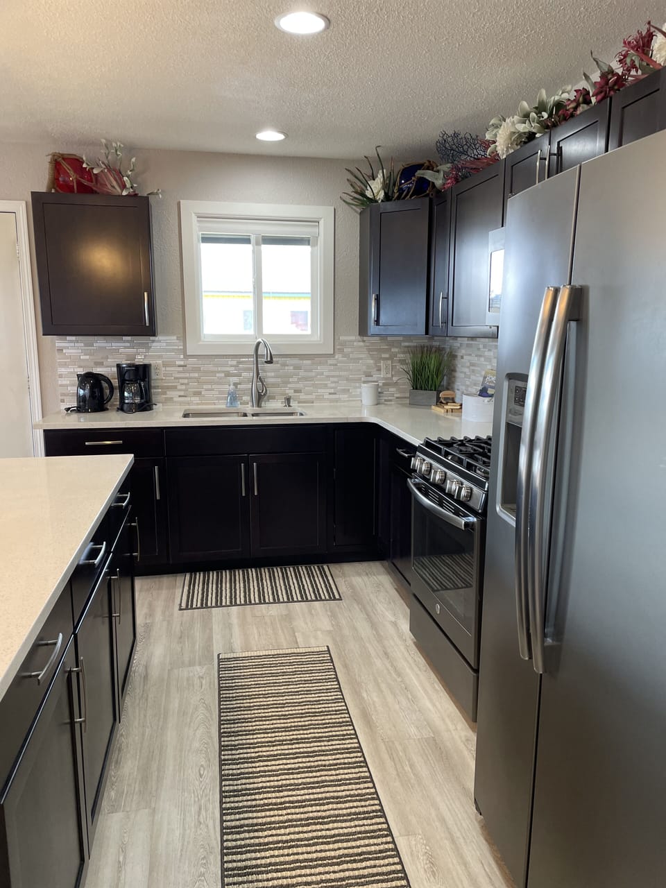 Kitchen area has full size refrigerator with freezer/ice maker